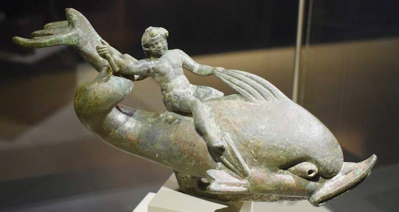 Estatuilla de bronce de Eros cabalgando sobre un delfín, expuesta en una vitrina del Museo Arqueológico de Éfeso en Selçuk